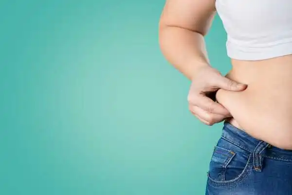Image of woman pinching her love handles to show weight gain Bletchley